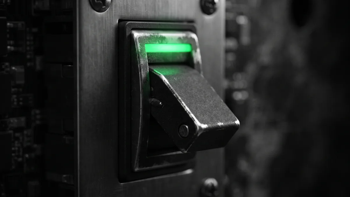 A circuit breaker partially toggled off with emerald green status light, representing a vendor access cut-off