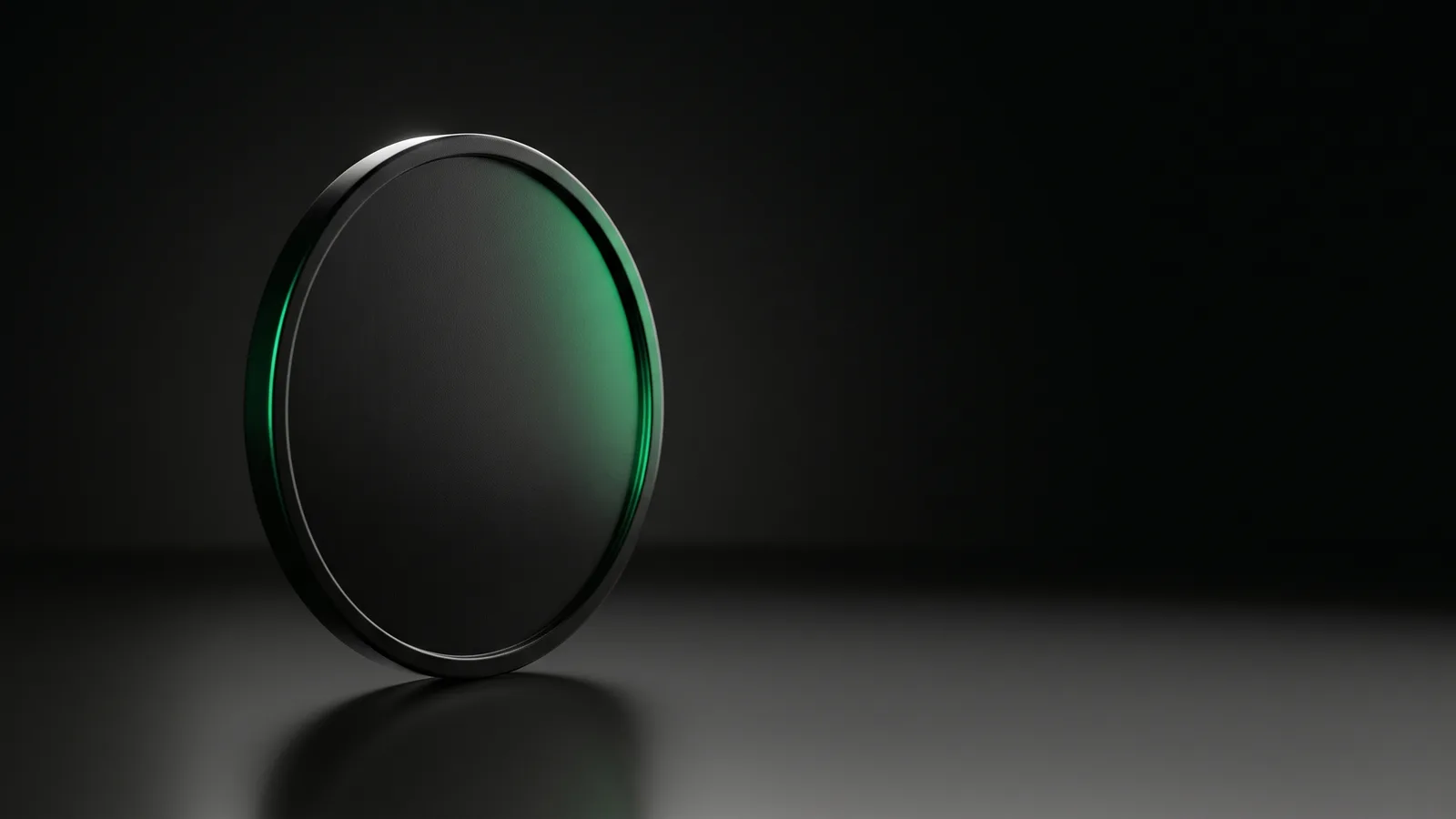 A single matte-black coin standing on its edge, vivid emerald light raking across its face